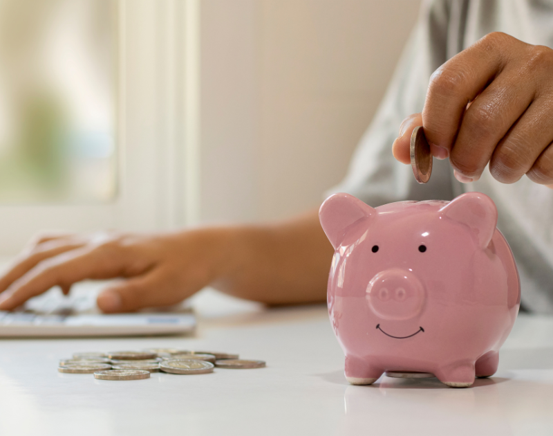 A person putting money into a piggy bank